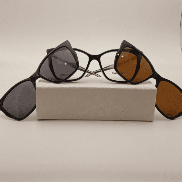 anteojo negro acetato sobre un estuche gris claro con los dos apliques sepia y gris